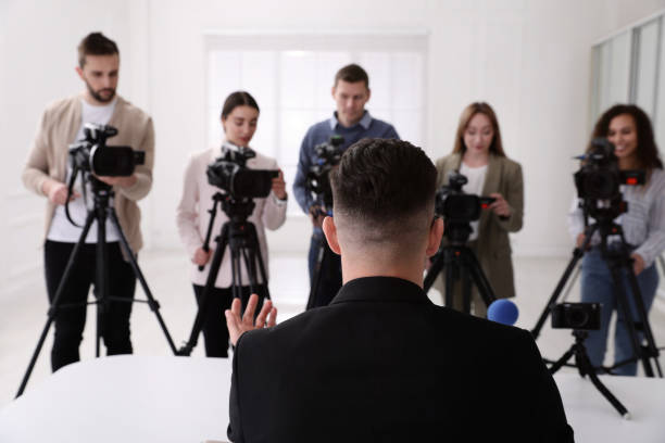 istock Businessman giving interview to journalists at official event, back view 1447075932