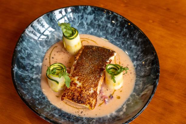 istock Top view of a pan fried salmon with cucumber rolls on a plate 1447076430