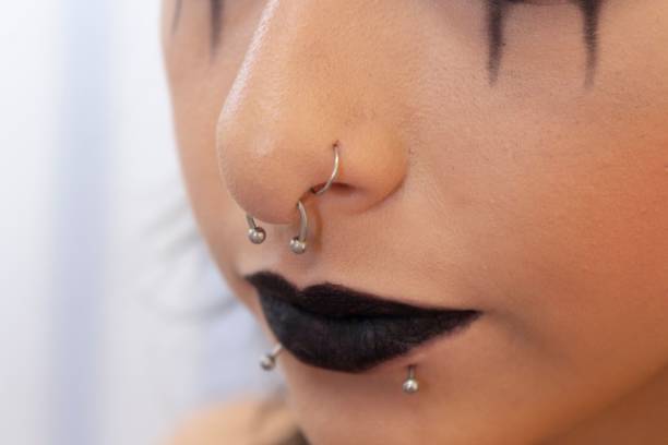 istock Face of a young model with makeup in a dark style and piercing 1447076609