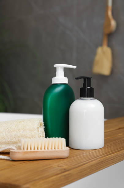 bandeja de baño de madera con botellas de geles de ducha, esponja vegetal y cepillo en la bañera interior - multi well trays fotografías e imágenes de stock