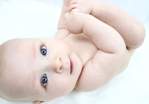 portrait of beautiful baby laying on bed,so cute