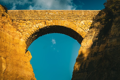 A stone arch with blue sky on the background