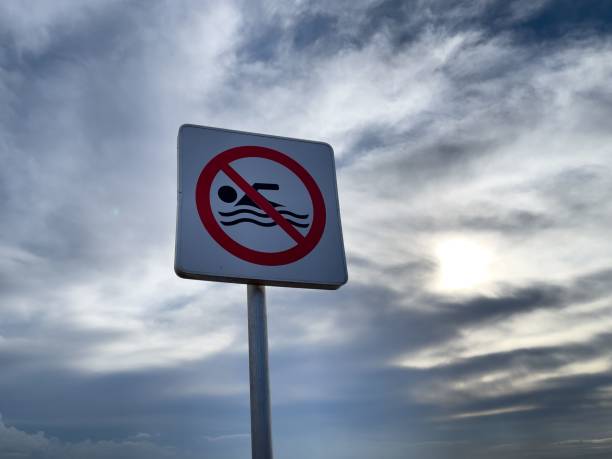 istock No swimming warning sign with blue sky in the background 1447081858