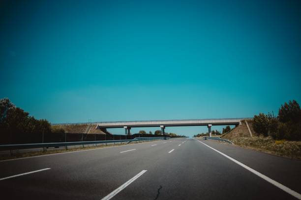 istock Bridge over a highway against the blue sky 1447084267