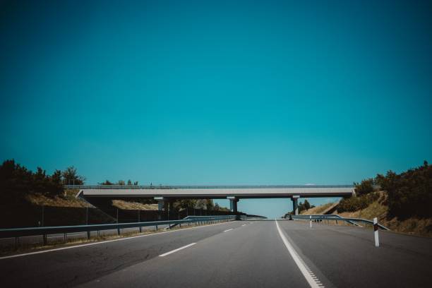 istock Bridge over a highway against the blue sky 1447084300