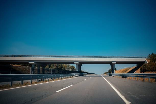 istock Bridge over a highway against the blue sky 1447084303