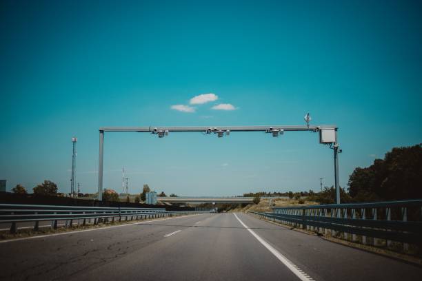 istock Clear highway road with white markings, railings and green trees around, under a blue sky 1447084311