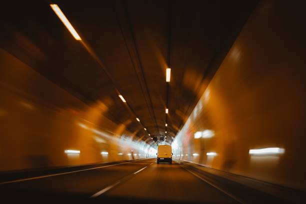 istock Illuminated road through a dark tunnel 1447084363