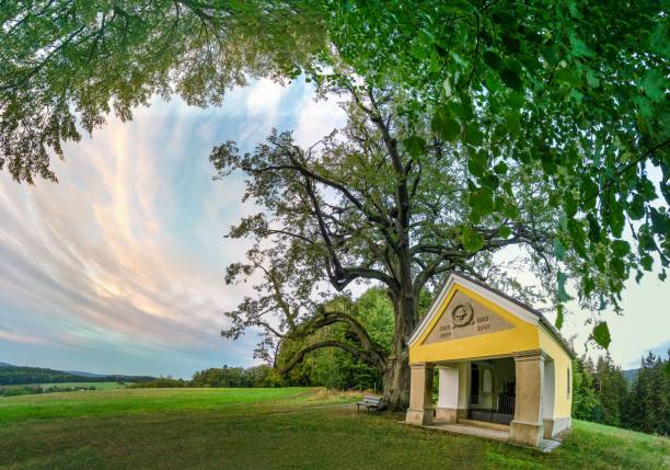 A small chapel in the field against a scenic cloudy sky