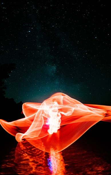 istock Vertical of a red magical pattern reflecting on water against a starry night sky 1447086070