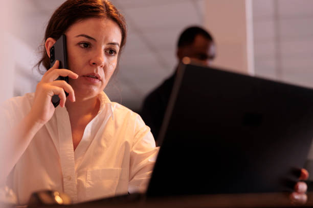 istock Employee discussing data on laptop website, talking on smartphone 1447087149