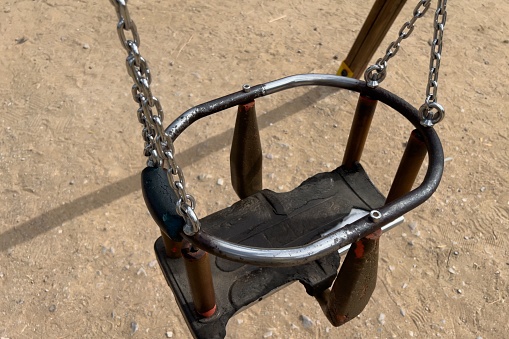 An empty swing in the park in
