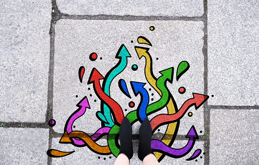 Selfie feet top view. choice business shoes walking. Future way forward movement. Woman wearing black boots fashion on tarmac road with colorful graffiti arrow sign. Creative and idea concept.