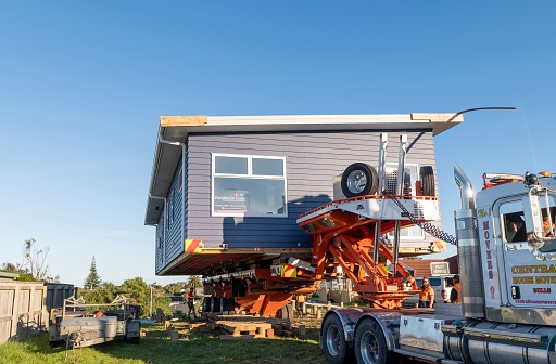 Otaki Beach, New Zealand – October 22, 2021: A huge truck moving a newly-constructed house to the permanent location
