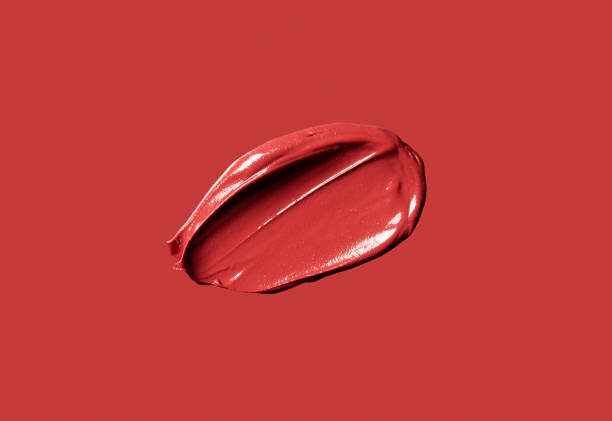 Red lipstick texture on red background. Red lipstick texture on red background. Cream makeup texture. Bright red cosmetic brush stroke sample. makeup swipes stock pictures, royalty-free photos & images