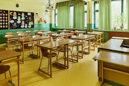 Empty classroom with wooden desks, white and green chalk boards in school. empty classroom. Abandoned School classroom with school desks and blackboard 4K