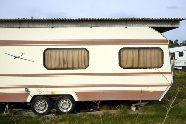 istock closeup of a light colored camper parked in a field under the sun 1447093080