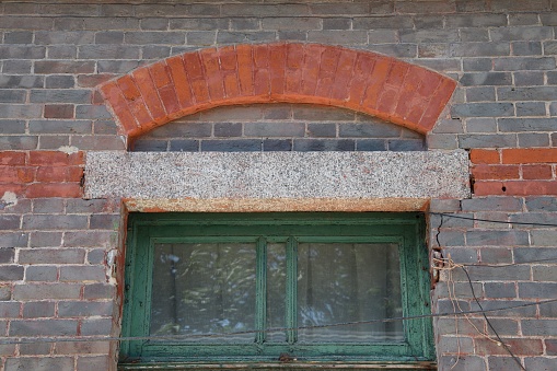 A closeup of a facade of an old Erqi factory with its broik wall and a little window, Beijing, China