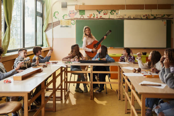 istock Happy elementary students having a music class with their teacher. 1447095579