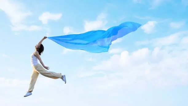 A woman flapping her wings and lightly flying in the sky