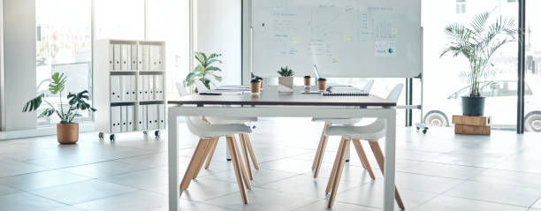 istock Empty boardroom, conference or meeting room with table, chairs and whiteboard. Business presentation office, corporate company interior space and furniture in modern workplace for discussion. 1447097974