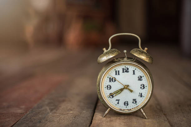 istock old alarm clock on wooden floor 1447098046