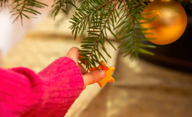 istock Hand of a child hanging a star on the Christmas tree 1447100621