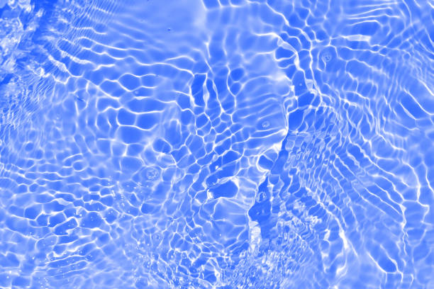 istock Defocus blurred transparent blue colored clear calm water surface texture with splashes and bubbles. Trendy abstract nature background. Water waves in sunlight with copy space. Blue watercolor shining 1447102020