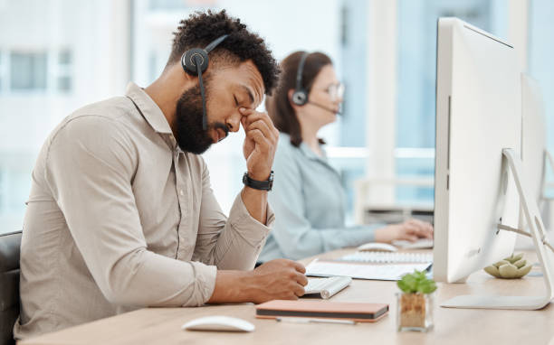 stress, mal di testa e call center uomo d'affari sul computer per il servizio clienti o consulenza. agente di supporto, uomo nero e consulente virtuale di telemarketing stanco, frustrato o burnout in ufficio di lavoro. - frustration telephone computer it support foto e immagini stock