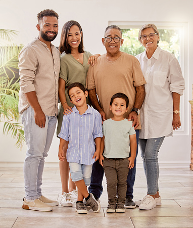 Happy family portrait with kids, parents and grandparents with smile standing in brazil home. Happiness, family and generations of men, women and children spending time together making fun memories.