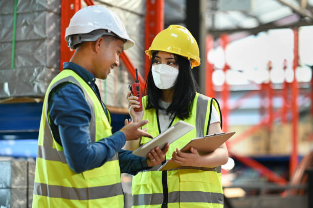 istock Female manager and male workers are checking order details on a tablet while standing between retail warehouse full of shelves. 1447105085