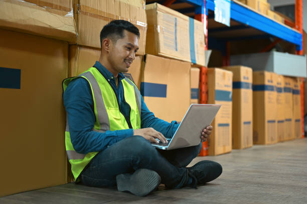 istock Man industrial worker checking stock and inventory on laptop while sitting in warehouse. Business factory industry concept. 1447105105