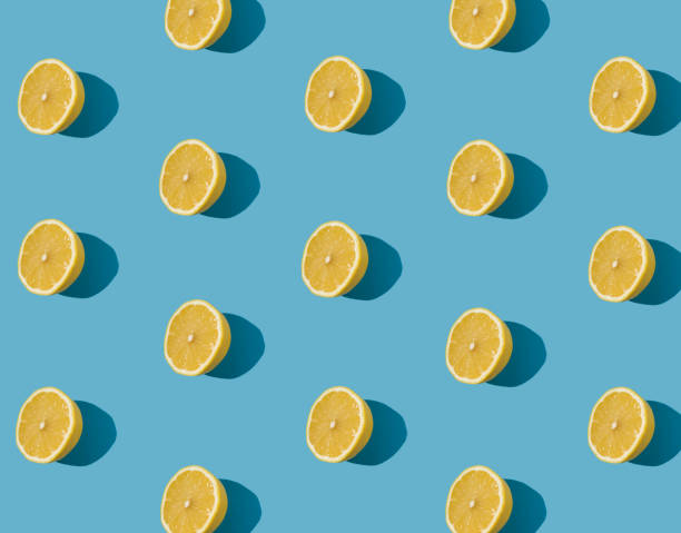 istock Summer pattern made with fresh yellow lemon slice on bright light blue background. Minimal background summer concept on bright sunlight. 1447106859