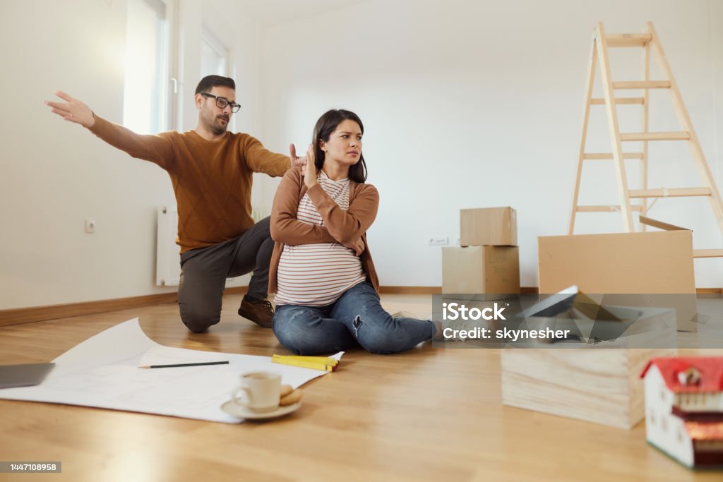 I don't want to hear a word anymore! Angry pregnant woman refusing to listen to her husband after moving into a new apartment. Copy space. Adult Stock Photo