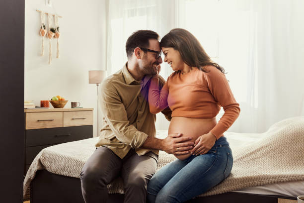 istock Affectionate pregnant couple relaxing on a bed in bedroom. 1447109787