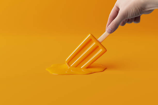 istock Hand holds melted orange ice lolly on a pastel background. 1447111041