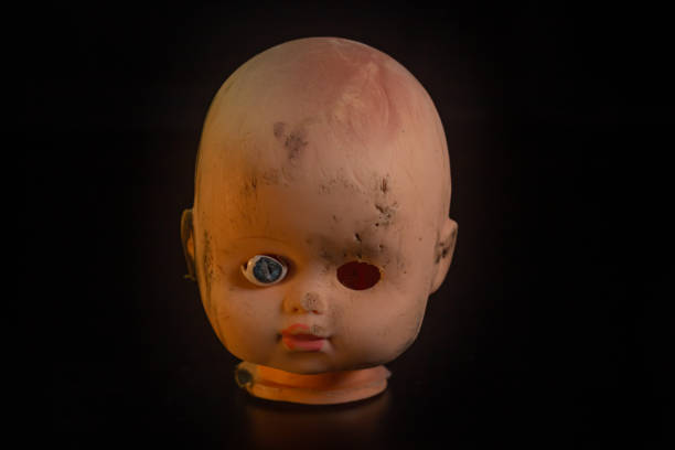 istock Damaged Dirty Doll head on black background isolated 1447113714