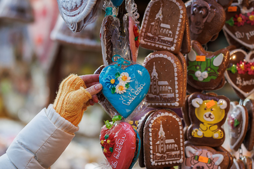 Woman buying gingerbread decorations at Christmas market stall