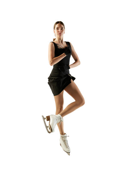 joven adolescente, patinadora artística femenina junior con traje de escenario negro patinando aislada sobre fondo blanco. concepto de habilidades, deporte, belleza, deportes de invierno - axel fotografías e imágenes de stock