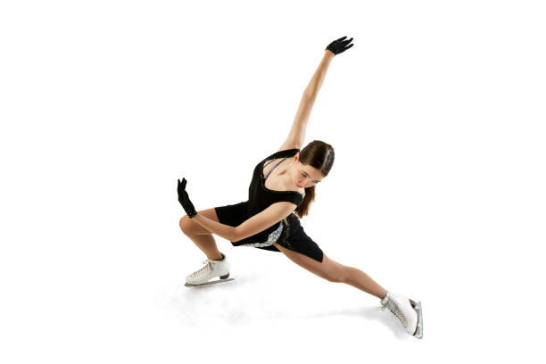 young teen girl, junior female figure skater in black stage costume skating isolated over white background. top view. art, skills, sport, beauty, winter sports - axel imagens e fotografias de stock