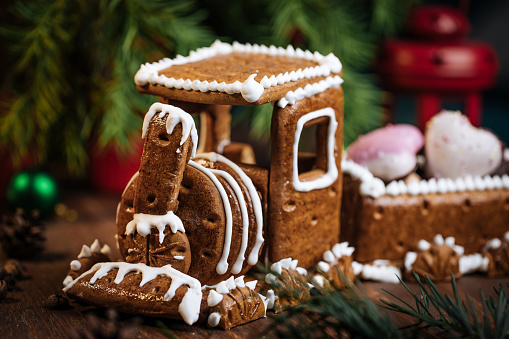 A woman is decoration ginger bread houses for Christmas