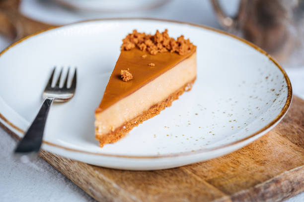 istock Cheesecake with Caramel Topping Sauce and Cookie Crumbles 1447115157