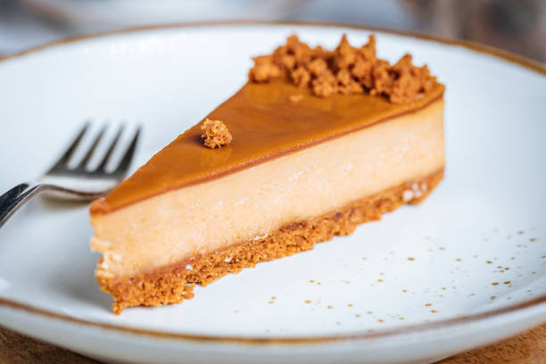 istock Cheesecake with Caramel Topping Sauce and Cookie Crumbles 1447115181