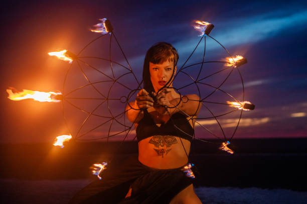 istock Beautiful brunette female fire dancer on the beach at night 1447115226
