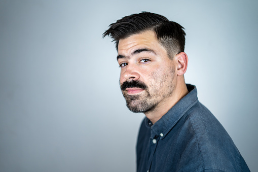 Confident American male entrepreneur with stubble. He is against white background.