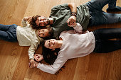 Happy family with a little girl lying on the floor