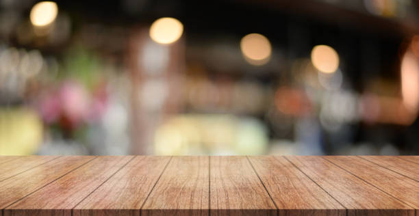 istock Empty wooden table top with lights bokeh on blur restaurant background. 1447123181