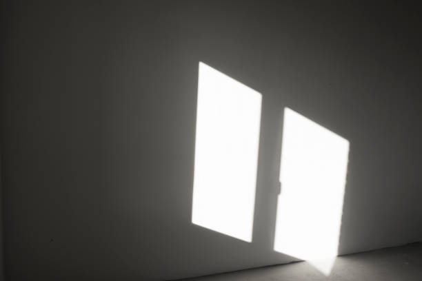 istock Shadow from the window on the gray wall. Abstract background with sunlight reflection on a vertical surface in the dark. 1447125424