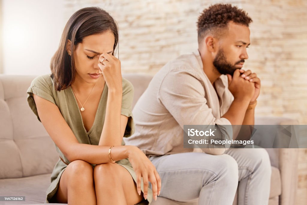Fight, divorce and depression with couple on sofa for conflict, therapy and mental health or marriage counseling. Sad, anxiety and stress with man and woman in living room for fail, crisis and angry Couple - Relationship Stock Photo