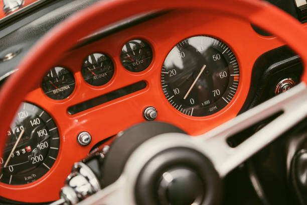 Close up hot of a vintage dashboard with various gauges on a retro car.
